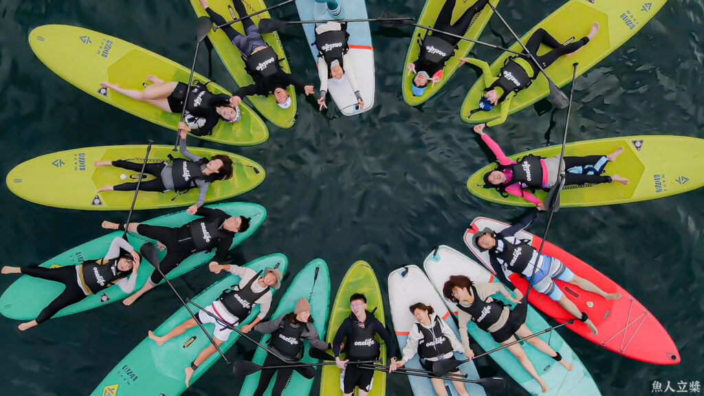 Coach photographing SUP paddlers with a DSLR camera on Sun Moon Lake during the Camera SUP tour